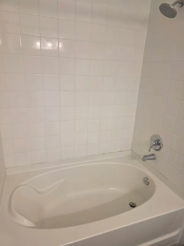 After: white tub and tile surround, clean and bright.